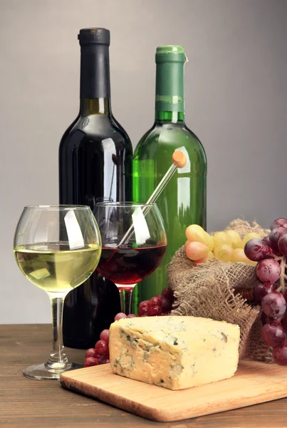 Composición con vino, queso azul y uva sobre mesa de madera, sobre fondo gris — Foto de Stock