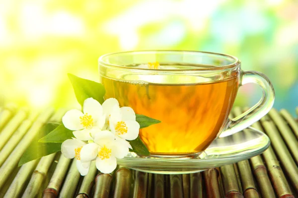 Cup of tea with jasmine, on bamboo mat, close-up — Stock Photo, Image