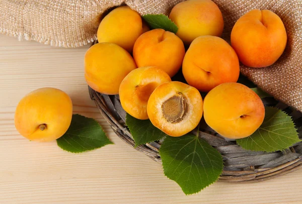 Apricots on wicker coasters on wooden table — Stock Photo, Image