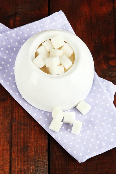 Açúcar refinado em tigela de açúcar branco em fundo de madeira — Fotografia de Stock