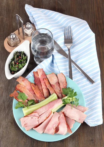 Bacon on plate on napkin on board on window table — Stock Photo, Image