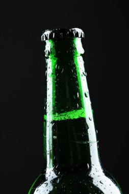 Siyah arka planda bir şişe bira.