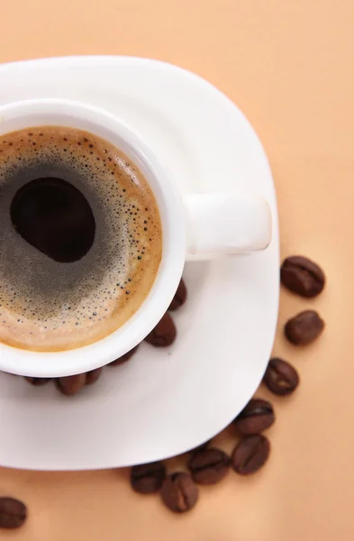 Taza de café con granos de café sobre fondo beige — Foto de Stock