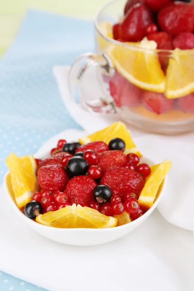 Ensalada de frutas útil en taza de vidrio y tazón en mesa de madera de primer plano —  Fotos de Stock