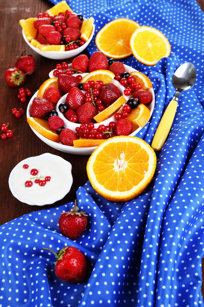 Полезный фруктовый салат в тарелках на деревянном столе крупным планом
