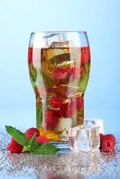 Eistee mit Himbeeren und Minze auf blauem Hintergrund — Stockfoto