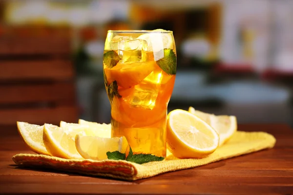 Té helado con limón y menta en la mesa de madera, al aire libre —  Fotos de Stock