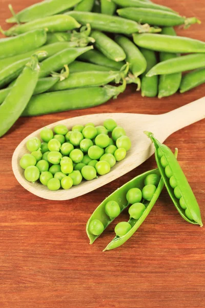 Guisantes verdes dulces sobre fondo de madera — Foto de Stock