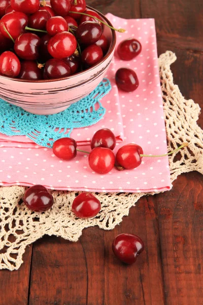 Ripe red cherry berries in bowl on wooden table close-up — Stock Photo, Image