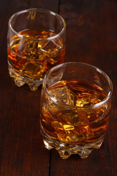 Copas de brandy con hielo sobre fondo de madera — Foto de Stock