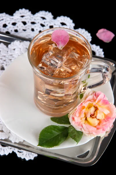 Glas kopje ijs thee uit de thee rose op metalen lade op servet op zwarte achtergrond — Stockfoto