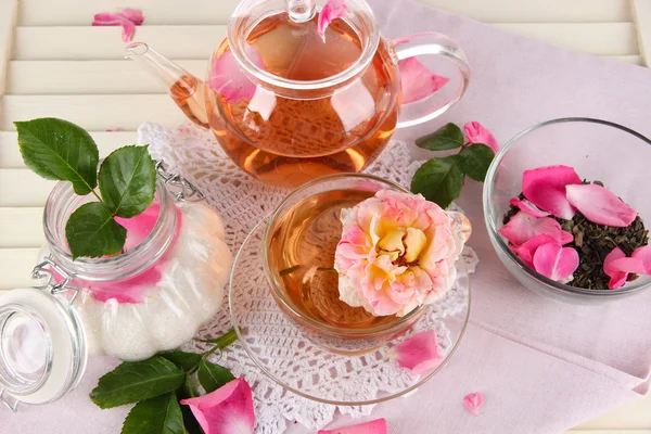Chaleira e xícara de chá de chá aumentou no guardanapo em fundo de madeira — Fotografia de Stock