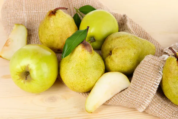 Pears on burlap on wooden table — Stock Photo, Image