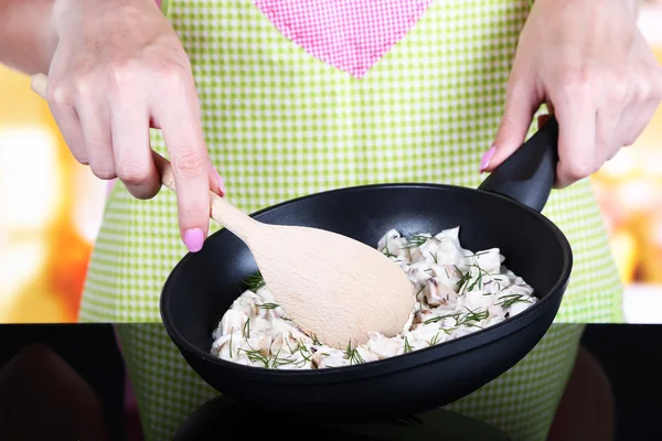 Mãos cozinhando molho de cogumelos na panela na cozinha — Fotografia de Stock