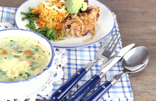 Sopa y arroz con carne en platos sobre servilletas sobre mesa de madera — Foto de Stock