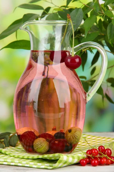 Кувшин компота с летними ягодами на естественном фоне — стоковое фото