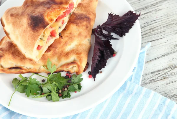 Pizzaschalen auf Teller auf Serviette auf Holztisch — Stockfoto