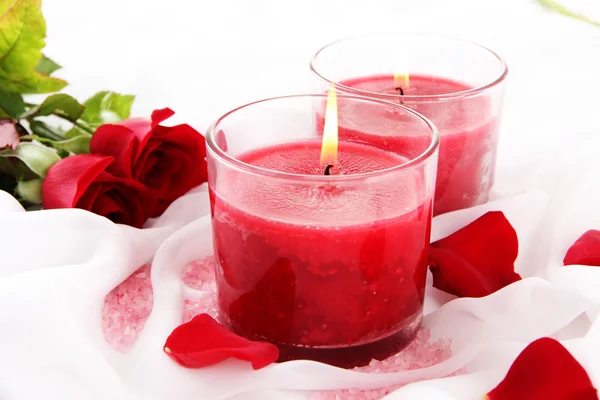 Beautiful candles with flowers on white cloth, close up — Stock Photo, Image