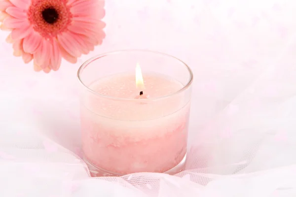 Beautiful candle with flower on white cloth, close up — Stock Photo, Image