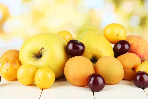 Bright summer fruits on wooden table on natural background — Stock Photo, Image