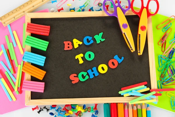 Kleine schoolbord met school levert op witte achtergrond. terug naar school — Stockfoto