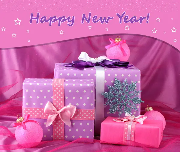 Beautiful gifts, Christmas balls and snowflake on a pink cloth — Stock Photo, Image