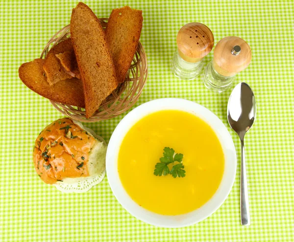 Ароматный суп в белой тарелке на зеленой скатерти — стоковое фото