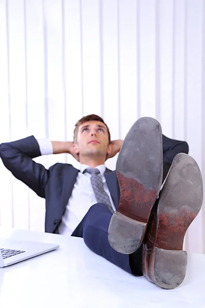 Uomo d'affari che riposa nel suo ufficio con le scarpe sul tavolo — Foto Stock