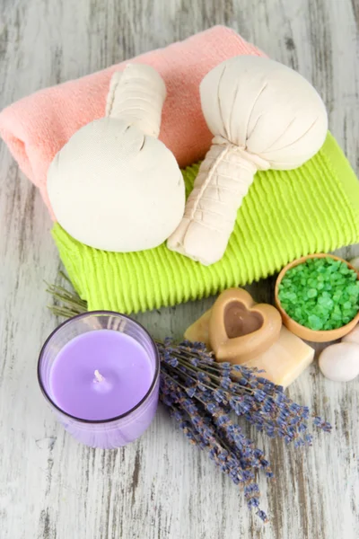 Bodegón con vela de lavanda, jabón, bolas de masaje, jabón y lavanda fresca, sobre fondo de madera — Foto de Stock
