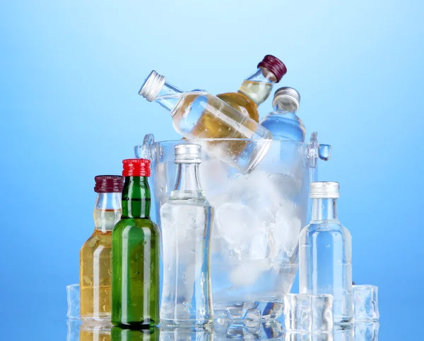 Minibar garrafas em balde com cubos de gelo, em fundo de cor — Fotografia de Stock