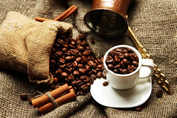 Coffee cup and metal turk on burlap background — Stock Photo, Image