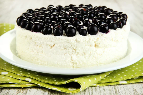 Чизкейк со свежими ягодами на белой тарелке на деревянном столе крупным планом — стоковое фото