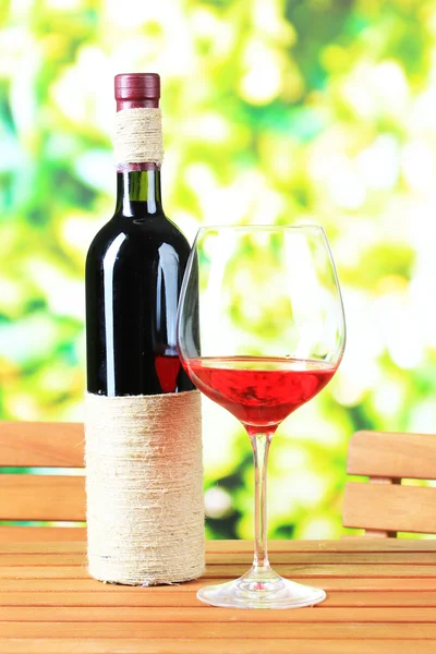 Glas vin på träbord på natur bakgrund — Stockfoto