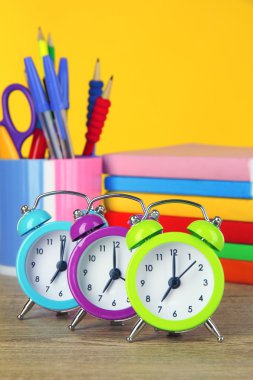 tabloda sarı arka plan üzerinde renkli çalar saat