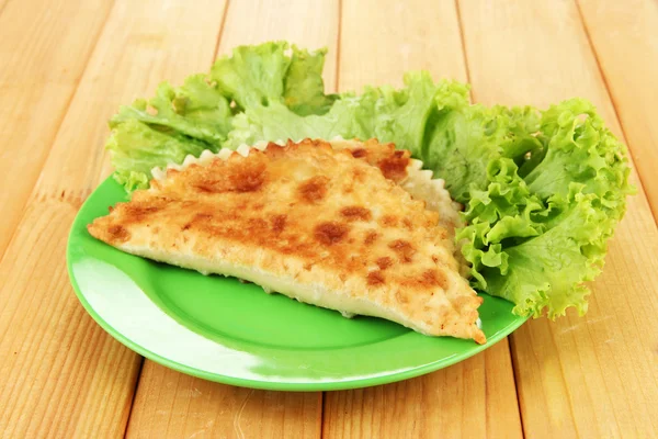 Chèques savoureux avec des herbes fraîches sur l'assiette, sur fond en bois — Photo