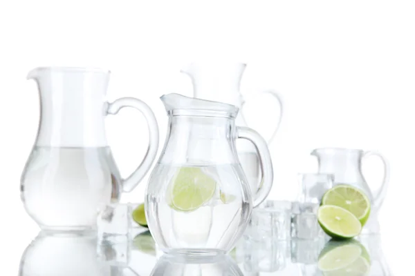 Glas kannor vatten med is och lime isolerad på vit — Stockfoto