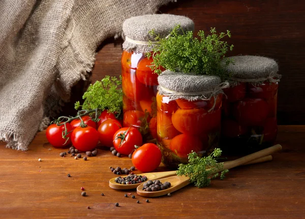 Tomates enlatados e frescos saborosos na mesa de madeira — Fotografia de Stock