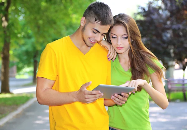 Due giovani studenti felici con computer portatile nel parco — Foto Stock