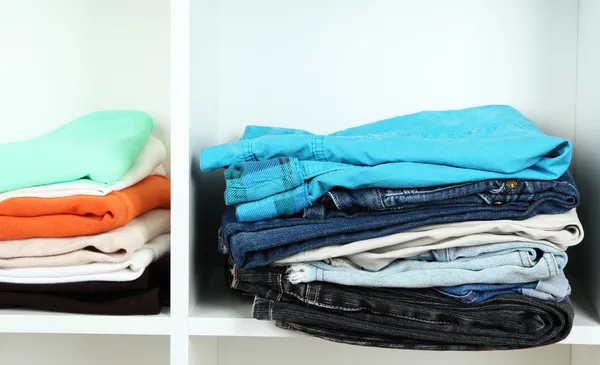 Clothes neatly folded on shelves — Stok fotoğraf