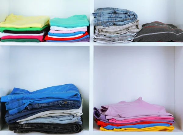 Clothes neatly folded on shelves — Stok fotoğraf