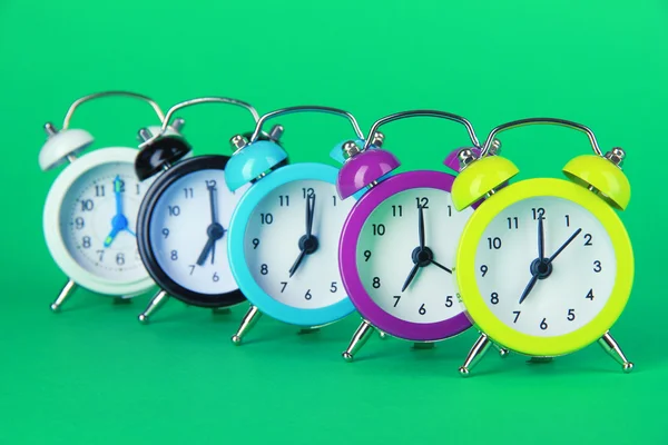 Reloj despertador colorido sobre fondo verde — Foto de Stock