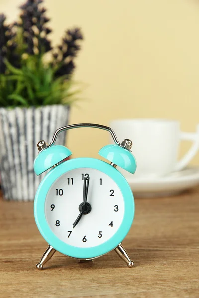 Reloj despertador azul en la mesa sobre fondo beige —  Fotos de Stock