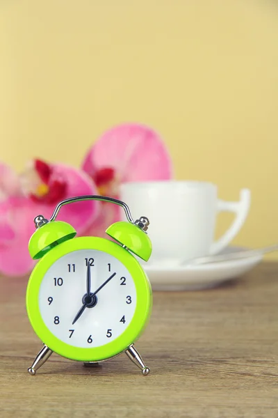 Relógio de alarme verde na mesa no fundo bege — Fotografia de Stock