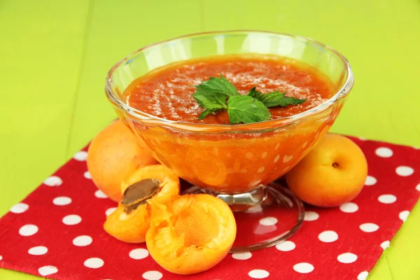 Marillenmarmelade in Glasschale und frischen Aprikosen, auf Holzgrund — Stockfoto