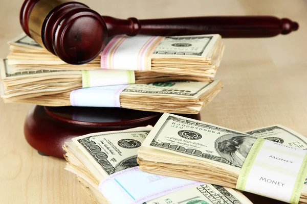 Stosy pieniędzy i sędziów młotek na drewnianym stole — Zdjęcie stockowe