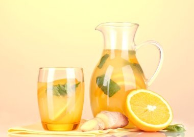 Turuncu limonata sürahi ve bardak Sarı zemin üzerine