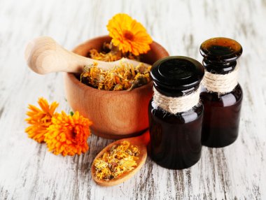 ilaç şişeleri ve ahşap zemin üzerine calendula çiçekler