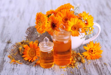 ilaç şişeleri ve ahşap zemin üzerine calendula çiçekler