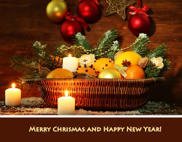 Composición navideña en cesta con naranjas y abeto, sobre fondo de madera —  Fotos de Stock