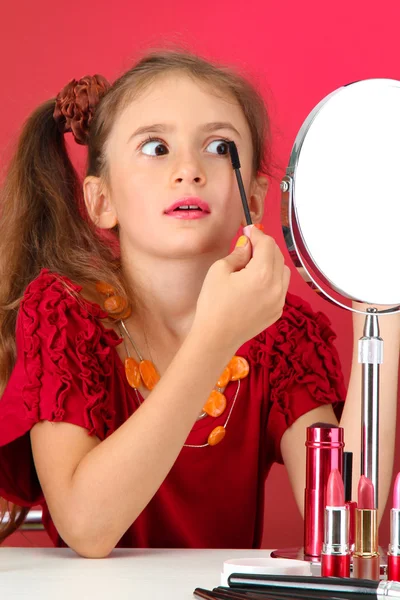 Niña en el vestido de su madre, está tratando de pintar sus pestañas — Foto de Stock